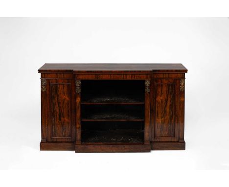 A William IV rosewood breakfront bookcase the central section fitted with adjustable shelves and flanked by cupboard drawers,