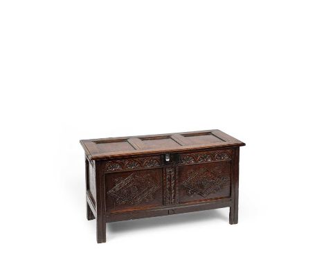 A Charles II oak panelled chest, Gloucestershire, with triple panel lid and twin panel front carved with foliate filled lozen