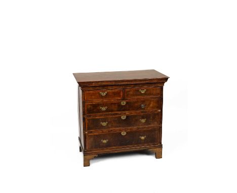 An early 18th Century walnut and crossbanded chest, fitted with a frieze drawer above two short and three long drawers on lat