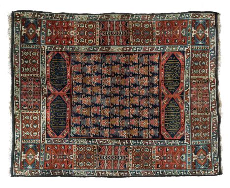 An Erivan rug, Armenia, the indigo field of serrated leaves with Kufic cartouche endpieces, framed by a wide brick red compar