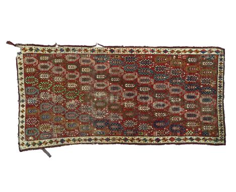 A South Caucasian rug, possibly Gendje, mid to late 19th Century, the strawberry red field with diagonal columns of polychrom