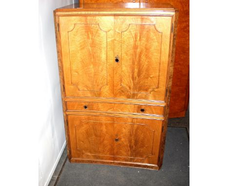 A walnut Art Deco design drinks cabinet, having maple lined interior, partitioned drawer and cupboard below, 84cm wide x 133c