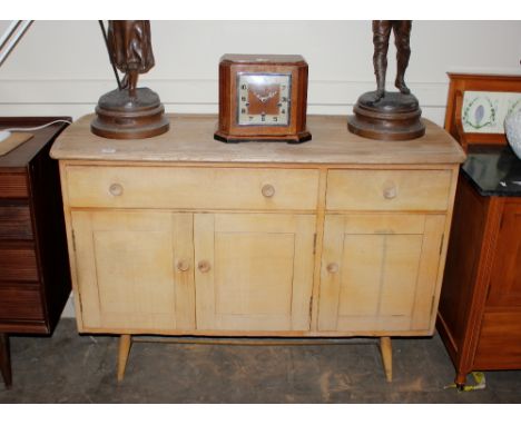A stripped elm Ercol sideboard fitted two drawers and cupboards below, raised on rounded tapering supports, 121cm wide x 47cm