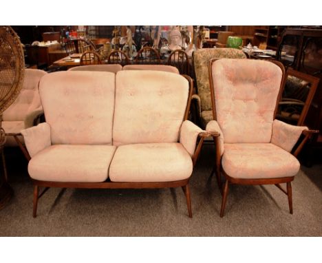 An Ercol cottage style two seater stick back settee and matching armchair 