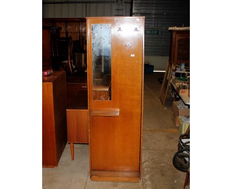 A 1960's oak hall stand / cupboard, fitted with chrome hooks, mirror panel and enclosed section, 61cm wide x 181cm high