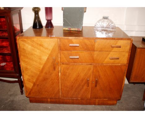 An Art Deco walnut sideboard fitted two long drawers above cupboards, flanked by a deep single cupboard, 120cm wide