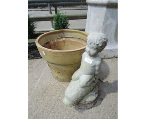 A cherub on dolphin garden ornament and plant pot