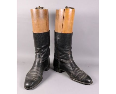A pair of vintage black leather riding boots, with wooden trees, one labelled 'Maxwell Dover Street, London'.