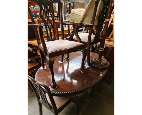 A mahogany wind out dining table on ball and claw feet and four Chippendale style chairs. 