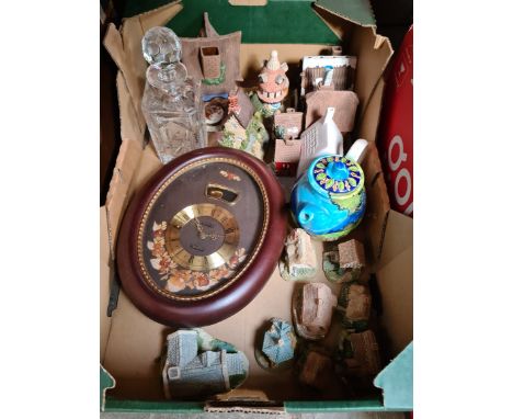 A box containing Lilliput Lane cottages, glass decanter, teapot and a clock.