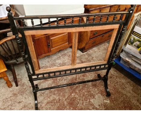 A late Victorian Aesthetic Movement ebonised fire screen with gilded detail. 