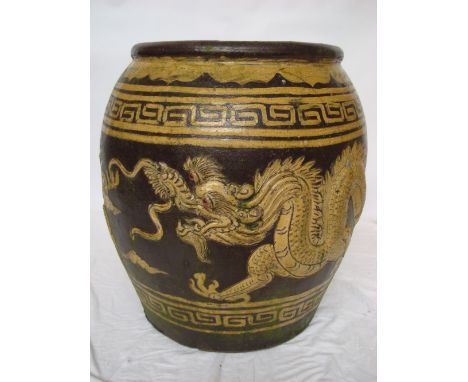 A large early 20th Century Chinese brown glazed planter, decorated  in relief with a dragon and phoenix chasing the flaming p