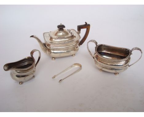 A matched George III silver three piece tea service.  Of oblong bellied form, on ball feet with gadrooned rims and bright cut