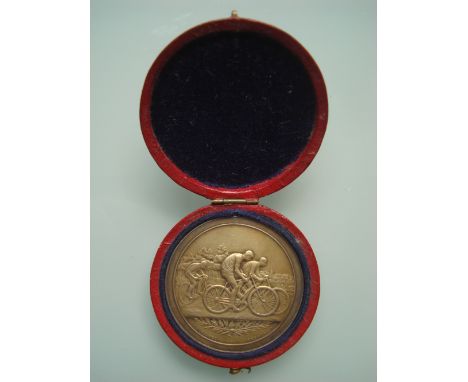 A late 19th Century French silver cycling medal, cast with bicyclists, verso with a laurel and oak wreath, engraved Cycle de 