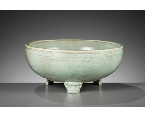 A CARVED AND MOLDED LONGQUAN CELADON TRIPOD CENSER, MING DYNASTYChina, 15th-16th century. The deep rounded sides with a gentl