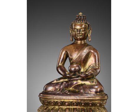 A GILT COPPER-ALLOY FIGURE OF BHAISHAJYAGURU, NEPAL, 13TH-14TH CENTURYThe Medicine Buddha seated in dhyanasana on a double lo