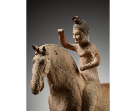 A PAINTED POTTERY FIGURE OF A POLO PLAYER, SUI TO TANG DYNASTYChina, 581-907. Modeled sitting in a saddle on a galloping hors