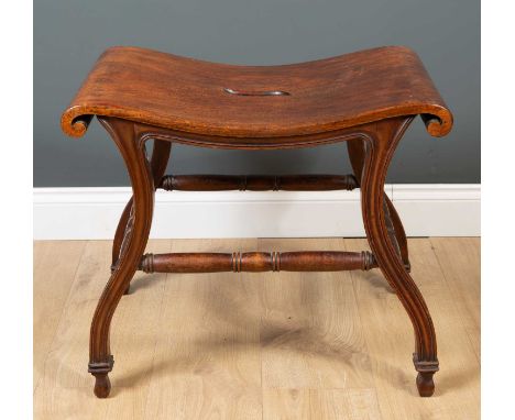 A Chippendale style mahogany hall stool the shaped top with scrolling ends, shaped fluted legs united by ring turned stretche