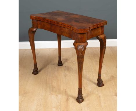 An Irish style fold over card table in the Georgian manner, the outswept supports decorated with shell and leaf carving, on h