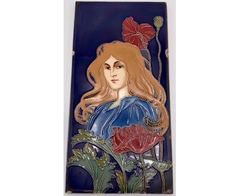 An Art Nouveau ceramic tile by Carl Sigmund Luber, depicting head and shoulders of woman in blue dress with auburn hair among