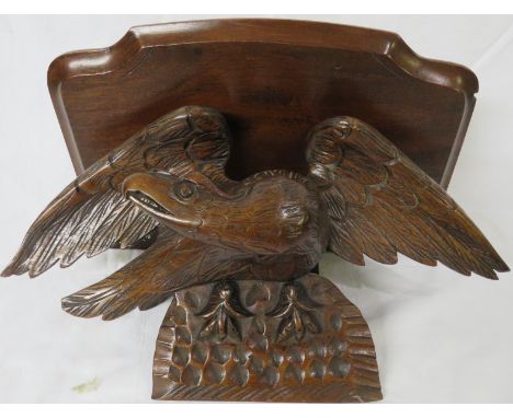 A single-shelf mahogany wall bracket raised and supported on a carved oak eagle, overall height 22cm, the shelf 40cm wide, 26