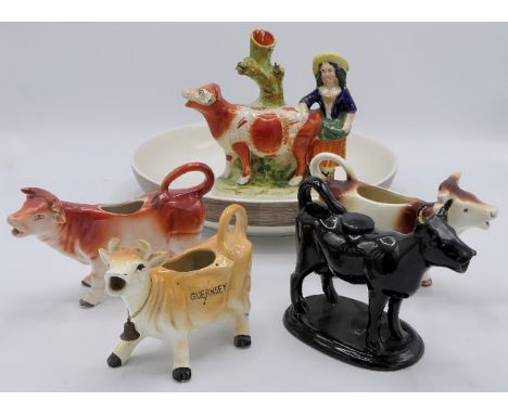 Four cow cream jugs, a Staffordshire pottery group of woman and cow (height 19cm), and a Next ceramic fruit bowl (diameter 30