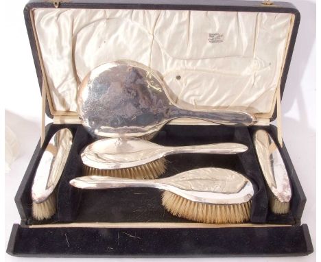 Cased George V silver backed dressing table set of plain design, each item with autograph inscription comprising hand mirror,