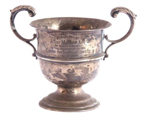 Victorian twin handled silver pedestal trophy, the baluster body with presentation engraving dated 1895, supported by flying 