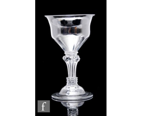 An 18th Century sweetmeat glass or champagne circa 1740, the ogee bowl above a stem with bladed collar over an eight sided Si