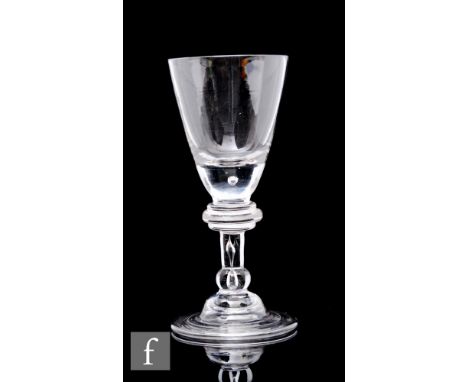 An 18th Century baluster drinking glass circa 1720 to 1730, the pointed round funnel bowl with solid base and an internal tea