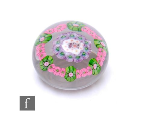 A 19th Century Clichy glass paperweight of domed form, internally decorated with a central red complex cane surrounded by a r