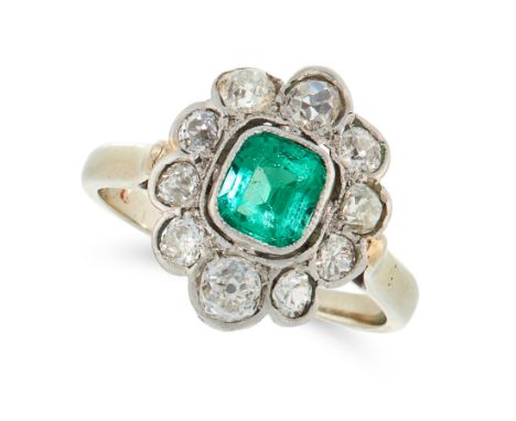 AN EMERALD AND DIAMOND DRESS RING set with a cushion cut emerald within a border of old cut diamonds, unmarked, size K / 5.5,