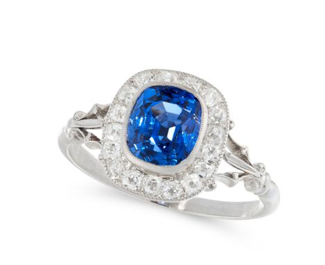 A CEYLON NO HEAT SAPPHIRE AND DIAMOND DRESS RING set with a cushion cut blue sapphire of 2.2 carats, within a border of old c