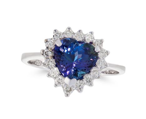 A TANZANITE AND DIAMOND DRESS RING in 18ct white gold, set with a heart cut tanzanite in a border of round cut diamonds, stam