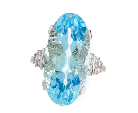 AN AQUAMARINE AND DIAMOND DRESS RING set with an oval cut aquamarine of 12.54 carats between stepped shoulders jewelled with 