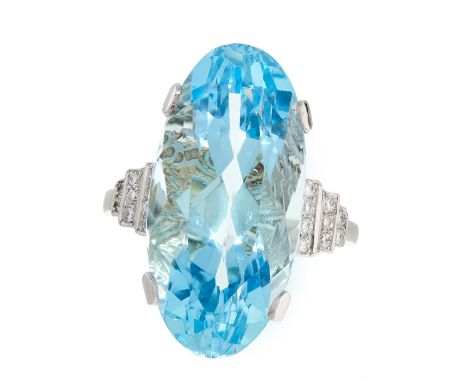 AN AQUAMARINE AND DIAMOND DRESS RING set with an oval cut aquamarine of 12.54 carats between stepped shoulders jewelled with 