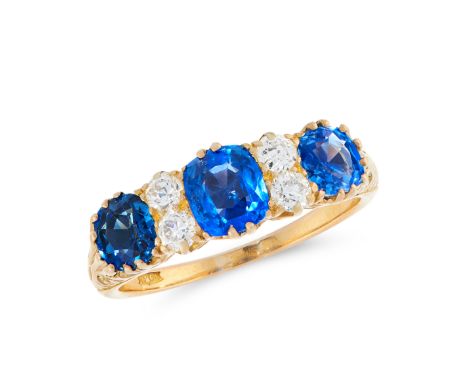 AN ANTIQUE SAPPHIRE AND DIAMOND DRESS RING in 18ct yellow gold, set with a trio of graduated cushion cut blue sapphires total