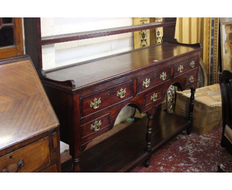 An late 18th/early 19th Century Century Welsh oak dresser with an open platerack, and five short drawers to potboard base wit