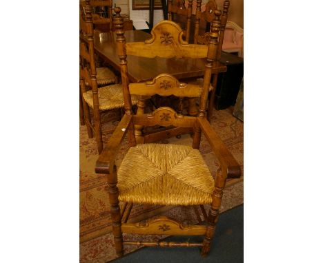 A Continental style beech dining table and set of six ladder back dining chairs each with rush seat 