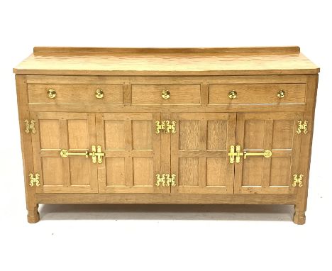 'Eagleman' adzed oak dresser, three drawers above two double cupboards enclosed by four panelled doors, brass fittings, by fo