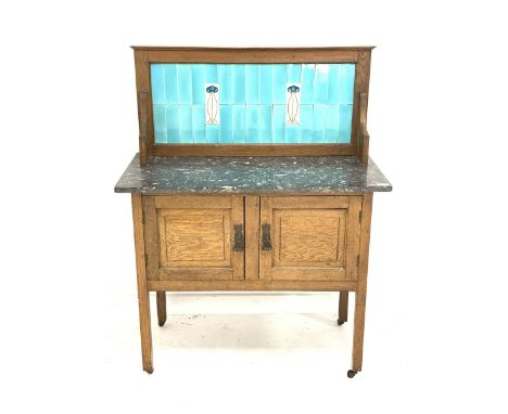 Arts &amp; Crafts period oak washstand with grey and white marble top and light blue tiled back with two tube lined contrasti