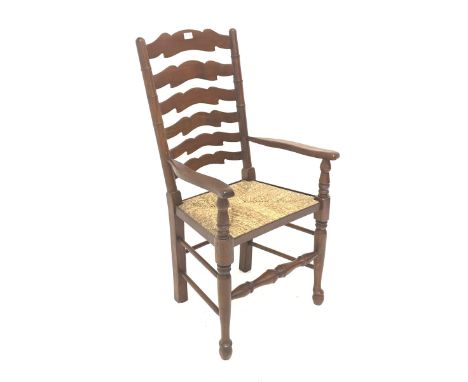 Late 20th century mahogany farmhouse style carver armchair, waved ladder back and rush seat, total width - 56cm - Condition R
