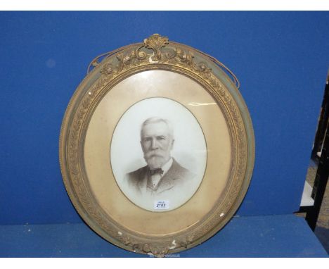An ornate oval frame black and white print of a portrait of a gentleman, some damage to frame.