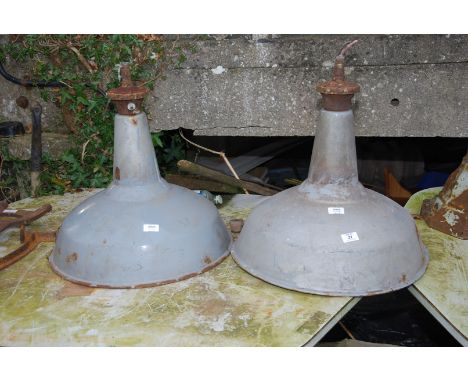 Two large enamelled industrial light shades.