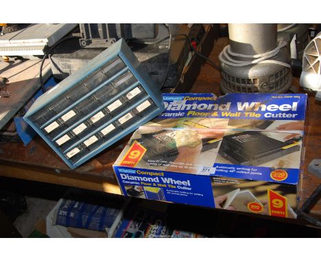 A ceramic tile cutter and a plastic storage box.