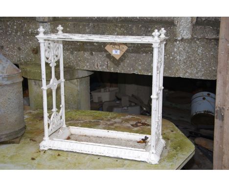 A cast iron stick stand with drip tray, 24'' wide x 10'' deep x 24'' high.