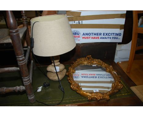 A table lamp and framed oval mirror.