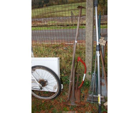 A quantity of tools, axe, hoe, bow saws, small hand shovel.