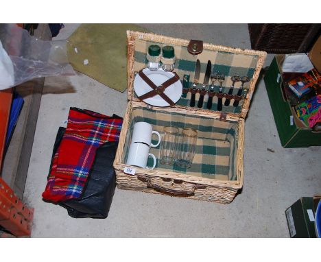 A picnic hamper and contents with picnic rug.