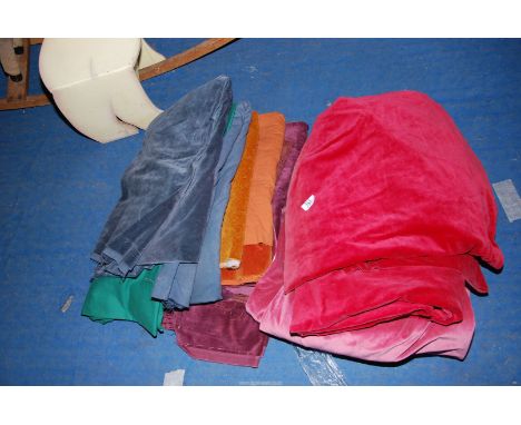 A pair of lined red cotton velvet curtains (as found) 68" drop x 39" wide and a quantity of mixed mainly cotton velvet remnan